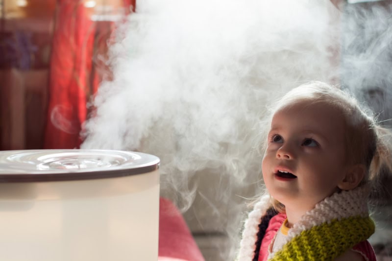 Little toddler watching steam from humidifier.